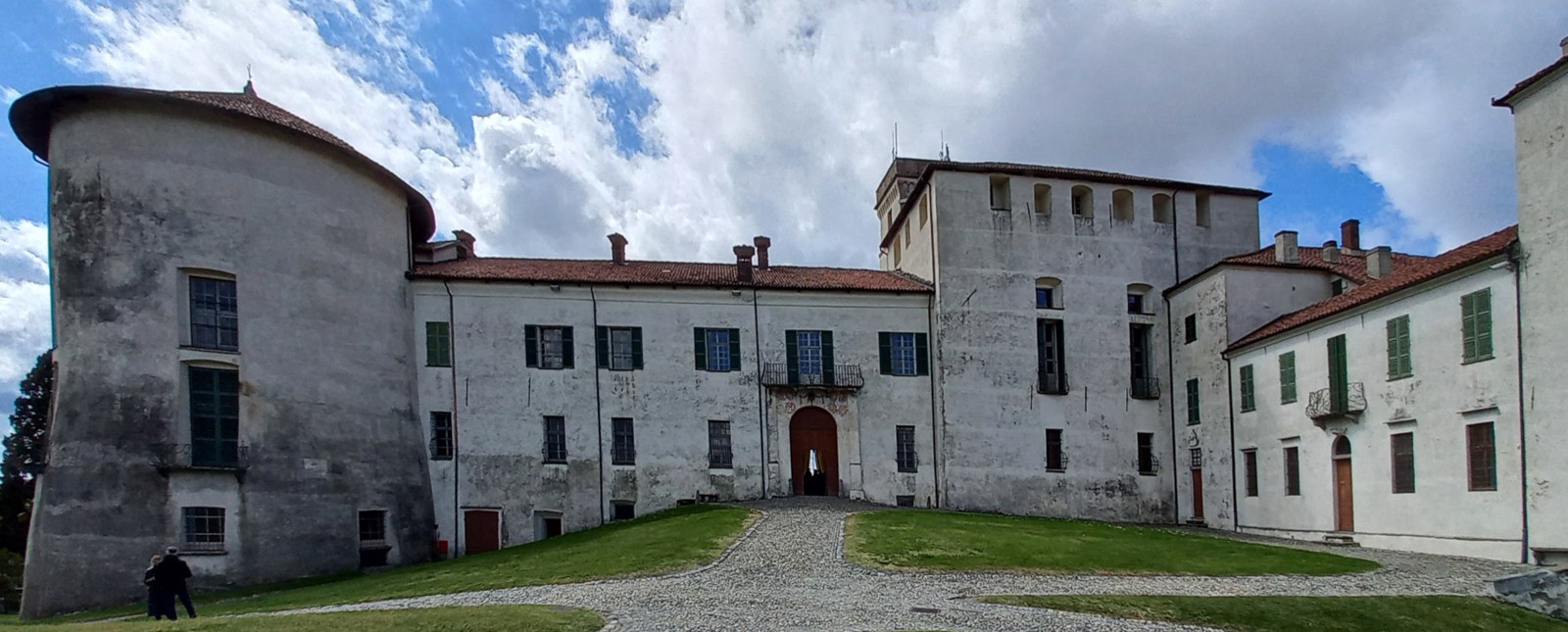 Fachadas e torres do Castelo de Masino em torno de uma área gramada