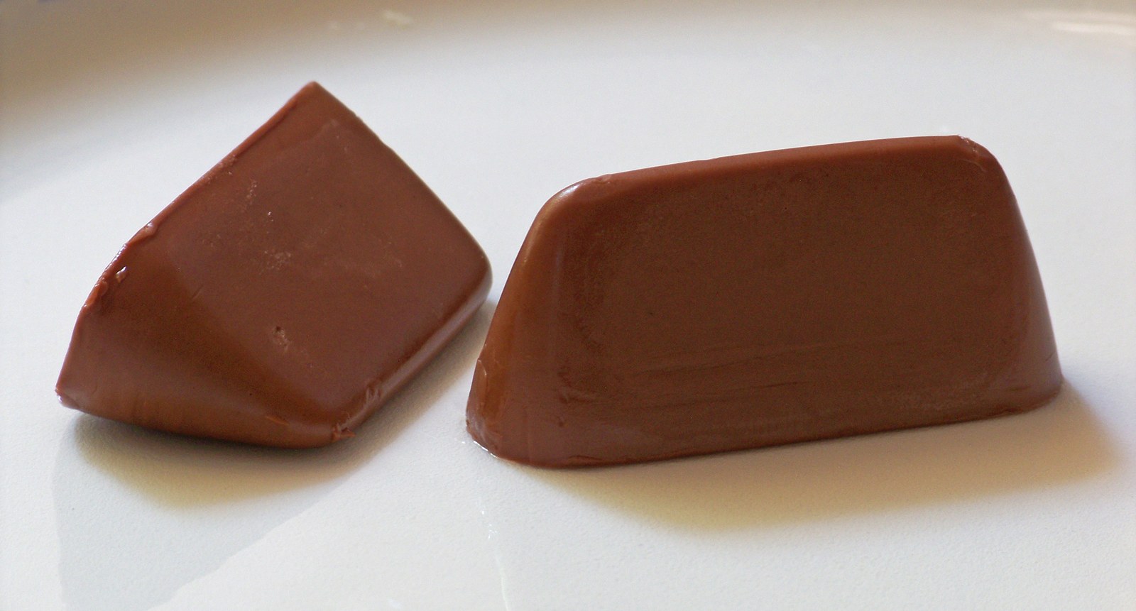 Dois gianduiotti, um deles em embalagem dourada e o outro aberto