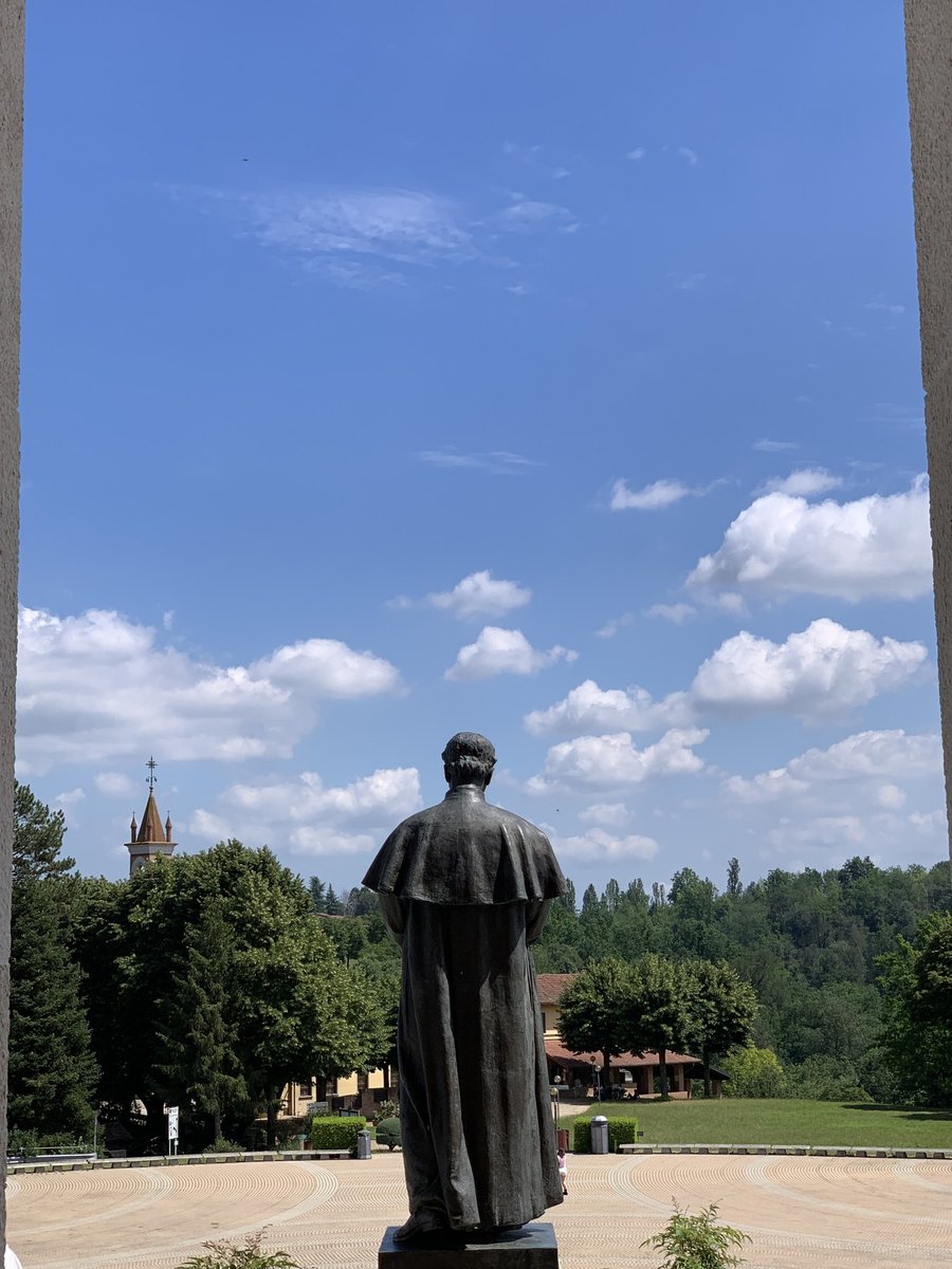 Estátua de Dom Bosco com a paisagem das colinas de Colle Don Bosco