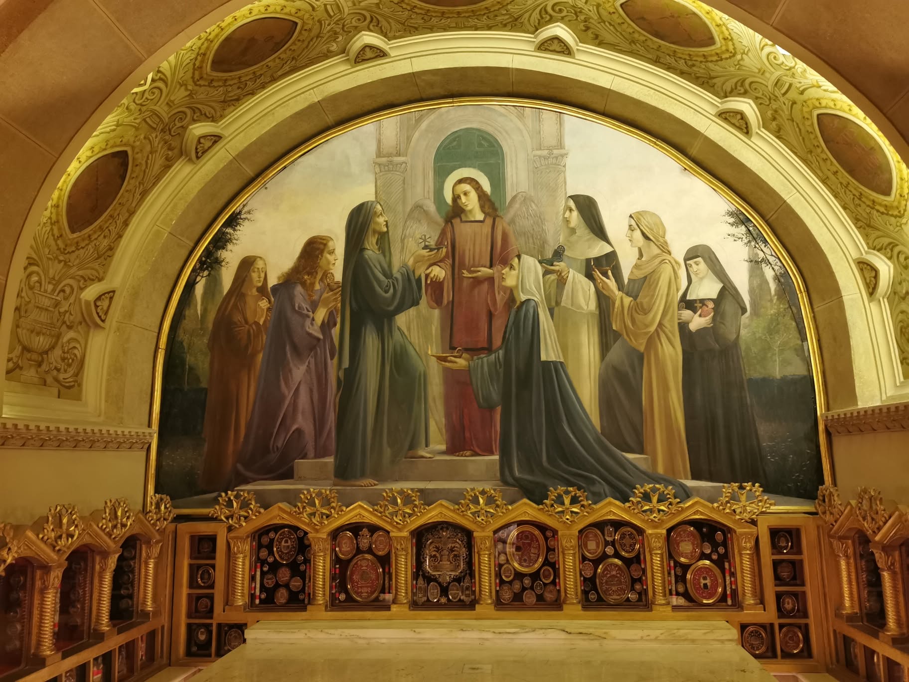 Pintura mural e pequenos relicários sob os arcos da cripta