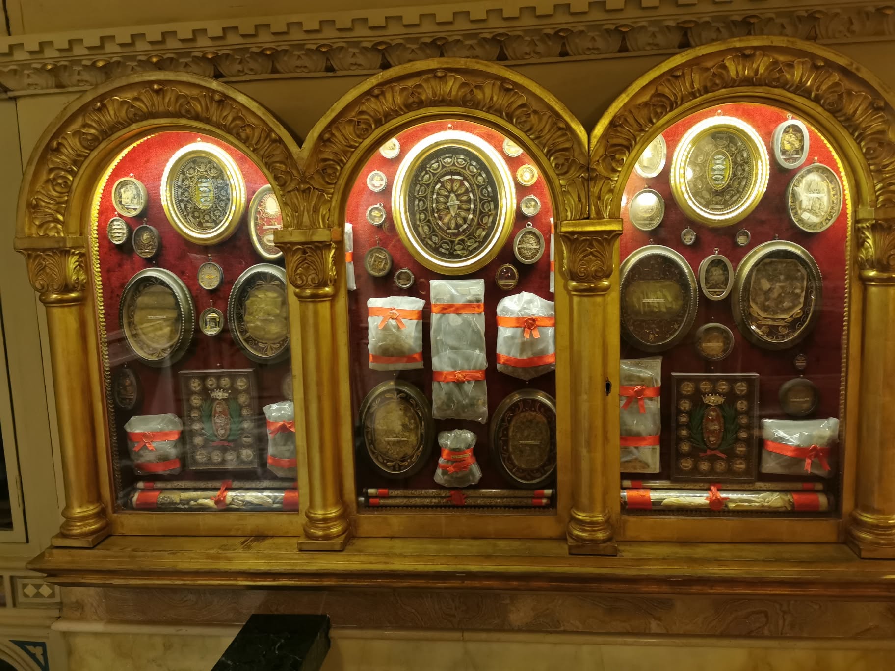 Vitrine com relíquias em arcos decorados na cripta de Valdocco