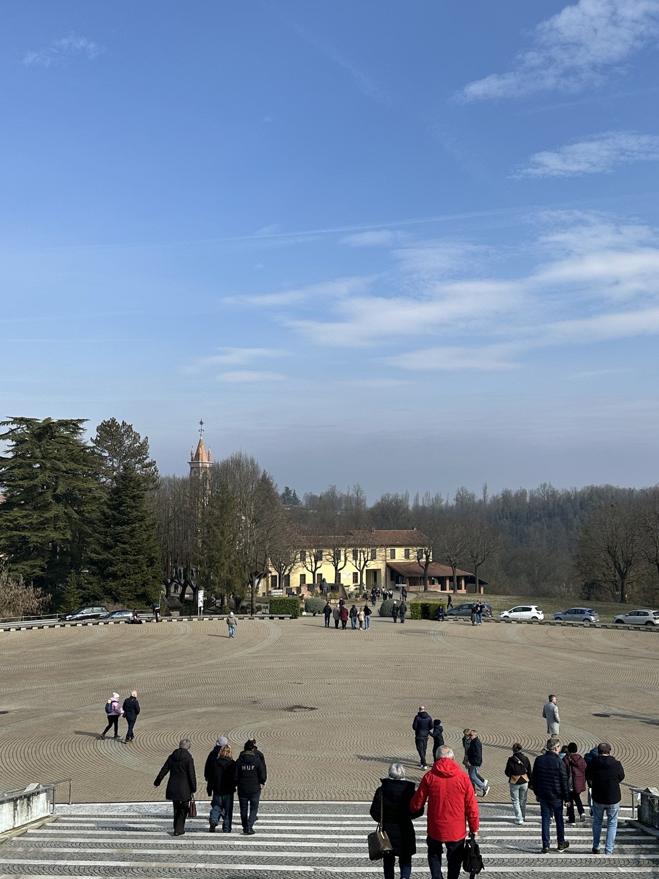 Área aberta do Prato del Sogno, com visitantes e colinas ao fundo no Colle Don Bosco