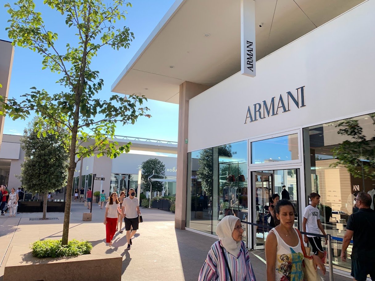 Pessoas caminhando diante de lojas em um centro de compras