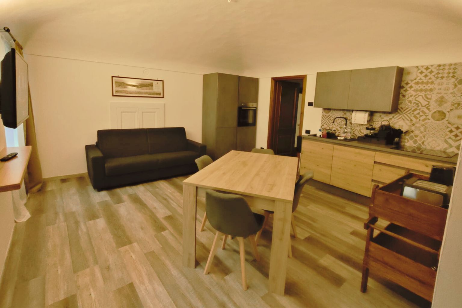 Ambiente com sofá, mesa e cozinha na La Bessolina