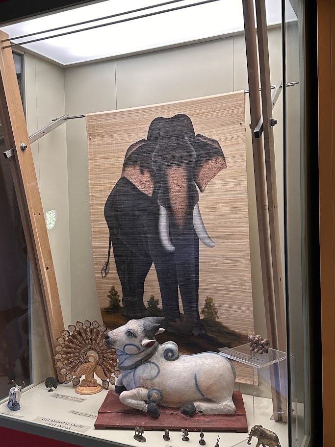 Painel com elefante e figura de bovino na seção indiana
