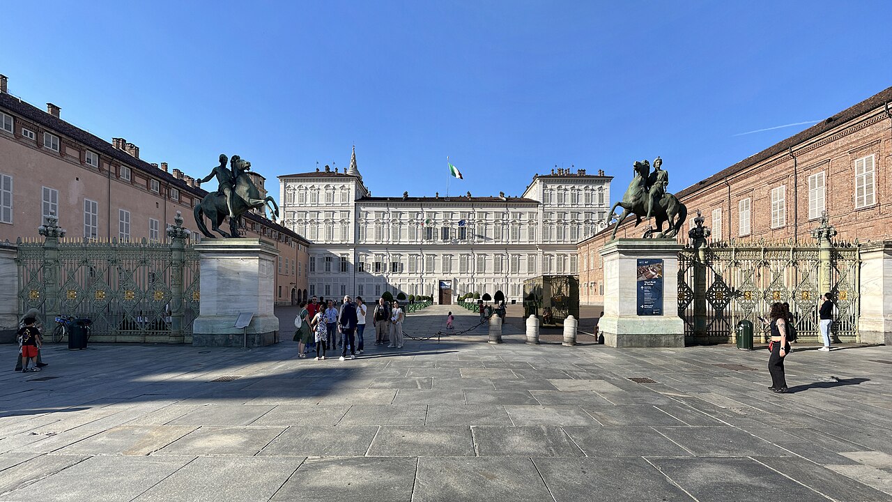 Fachada do Palazzo Reale de Turim diante de um pátio, com esculturas equestres junto ao portão