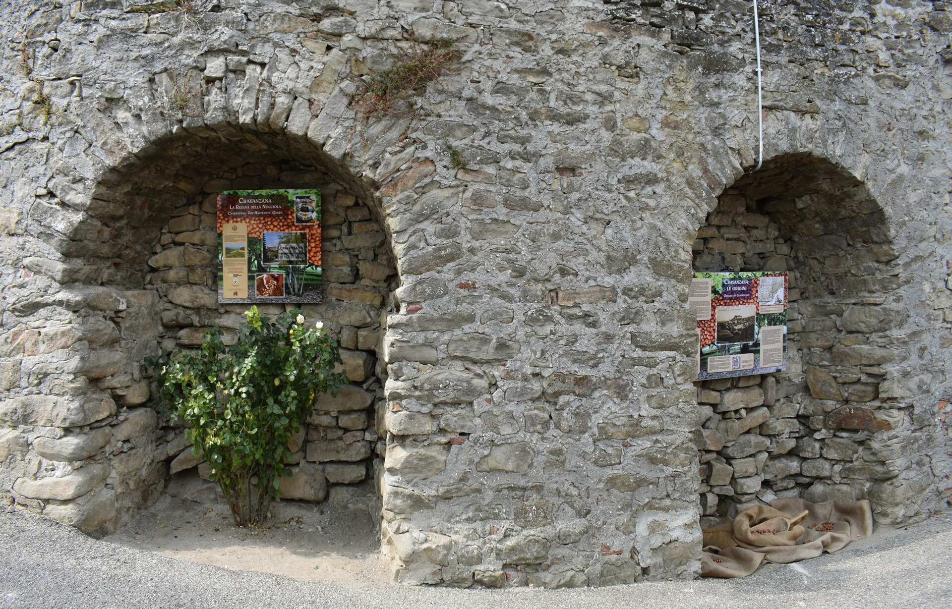 Painéis sobre a avelã em nichos de um muro de pedra, em Cravanzana
