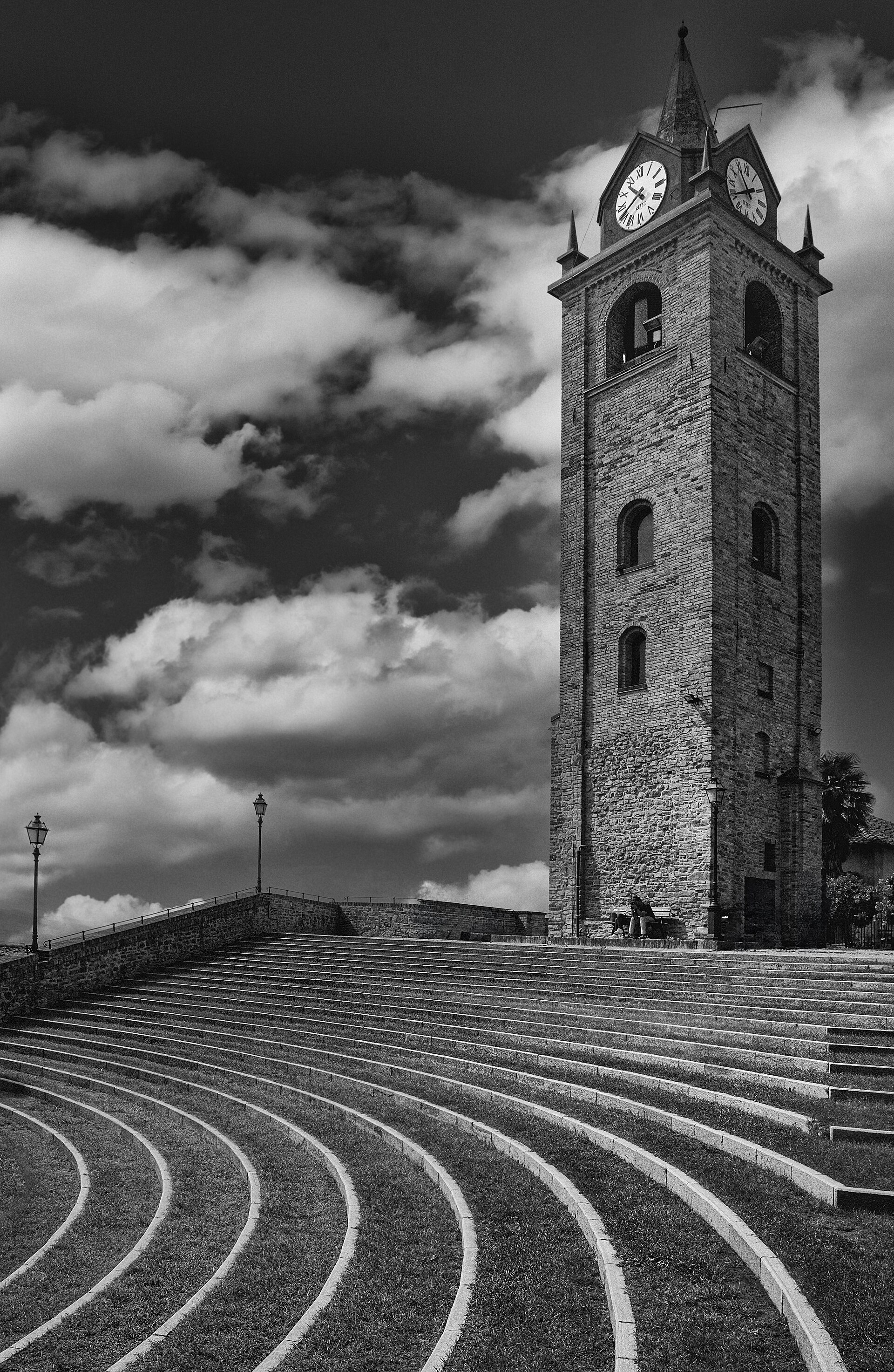Fotografia em preto e branco da torre com relógio e dos degraus do Auditorium Horszowski, em Monforte d’Alba