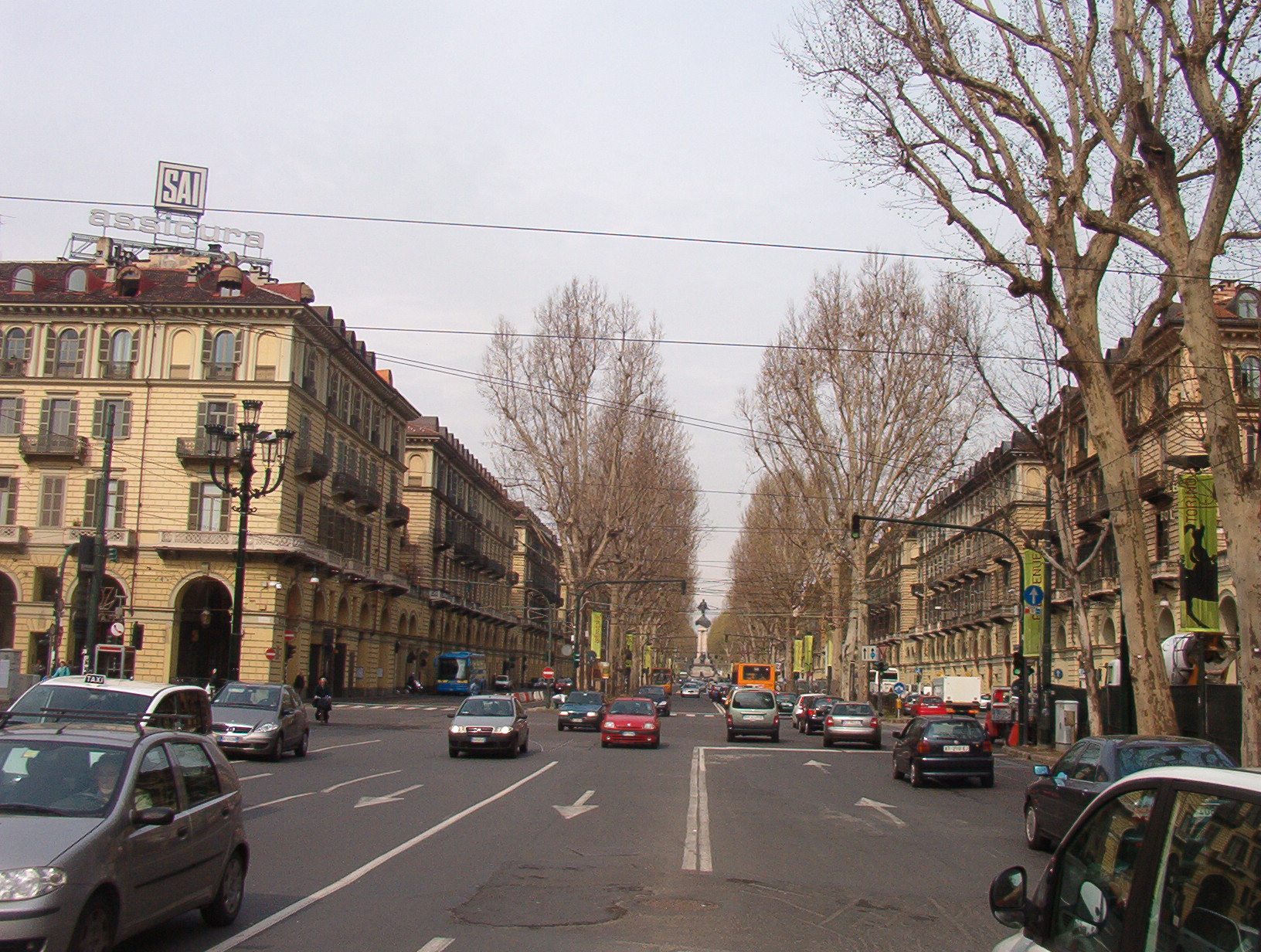 Corso Vittorio Emanuele II com árvores, automóveis e transporte público em Turim